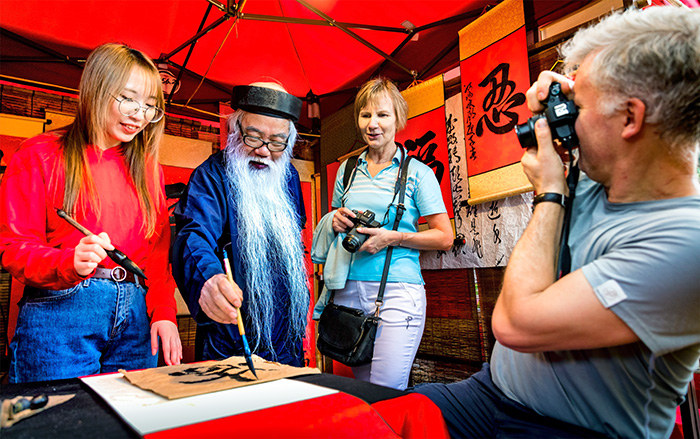 Visitors experience Vietnamese calligraphy. Photo: Pham Dinh Thanh